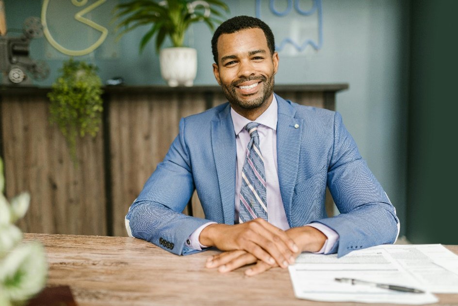 Man in a blue suit sitting and posing