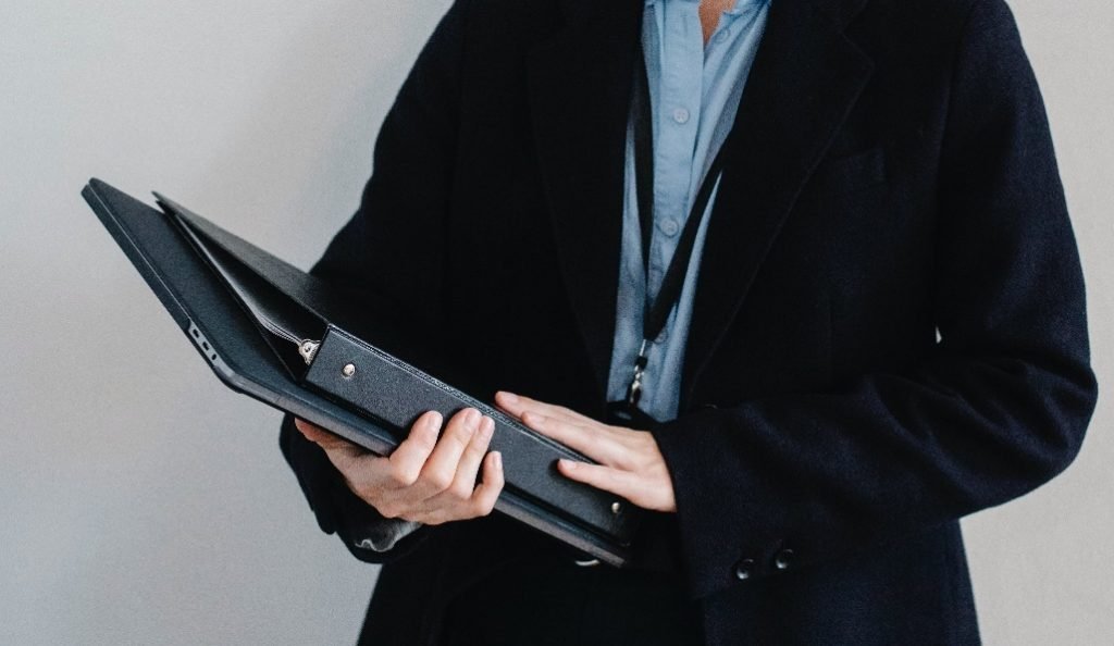 A person in a suit holding files