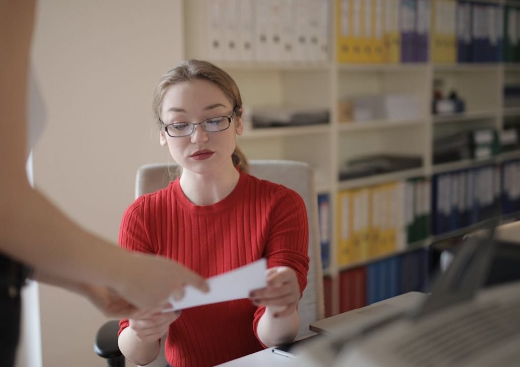 A woman in a red shirt going through a document